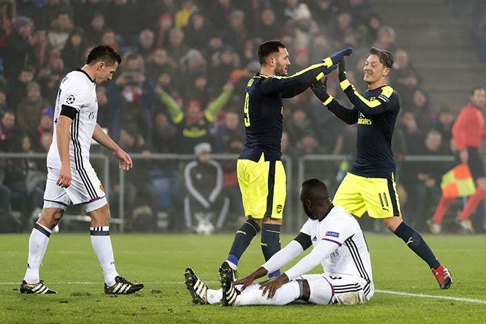 Arsenal's Lucas Perez, back left, and Mesut Oezil, back right, cheer after Arsenal's second goal during their Champions League Group stage Group A soccer match between Switzerland's FC Basel 1893 and England's Arsenal FC in the St. Jakob-Park stadium in Basel, Switzerland, on Tuesday, Dec. 6, 2016. (Walter Bieri/Keystone via AP)