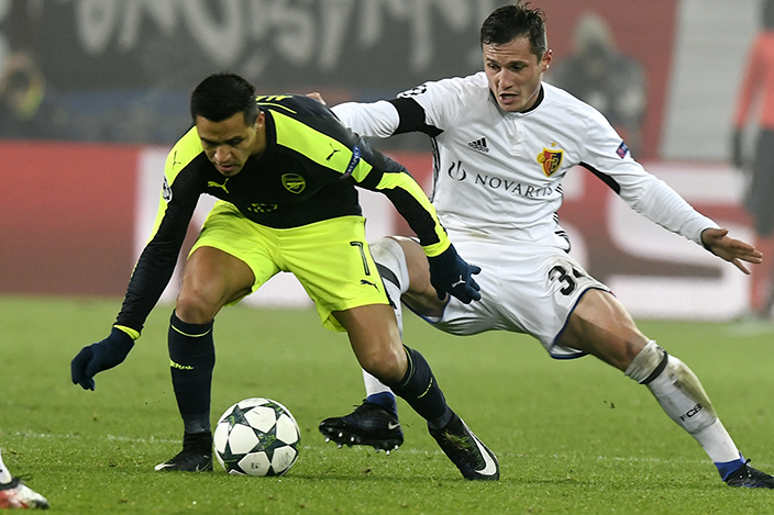 Basel's Taulant Xhaka, right, fights for the ball against Arsenal's Alexis Sanchez during their Champions League Group stage Group A soccer match between Switzerland's FC Basel 1893 and England's Arsenal FC in the St. Jakob-Park stadium in Basel, Switzerland, on Tuesday, Dec. 6, 2016. (Walter Bieri/Keystone via AP)