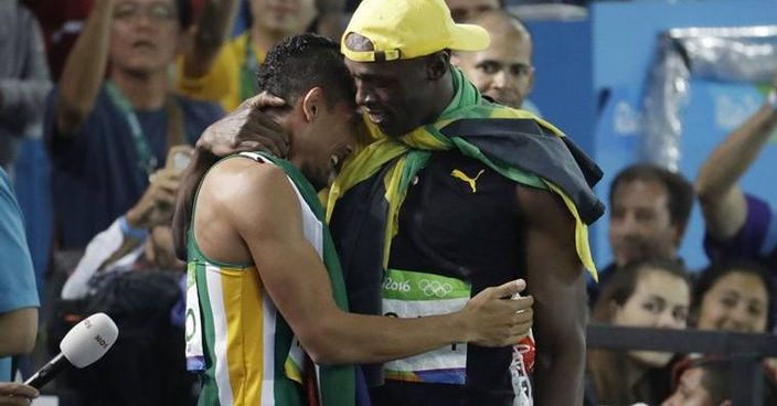 Jamaica's Usain Bolt, right, winner of the men's 100-meter final embraces South Africa's Wayde Van Niekerk, winner of the men's 400-meter final during the athletics competitions of the 2016 Summer Olympics at the Olympic stadium in Rio de Janeiro, Brazil, Sunday, Aug. 14, 2016. (AP Photo/Julio Cortez)