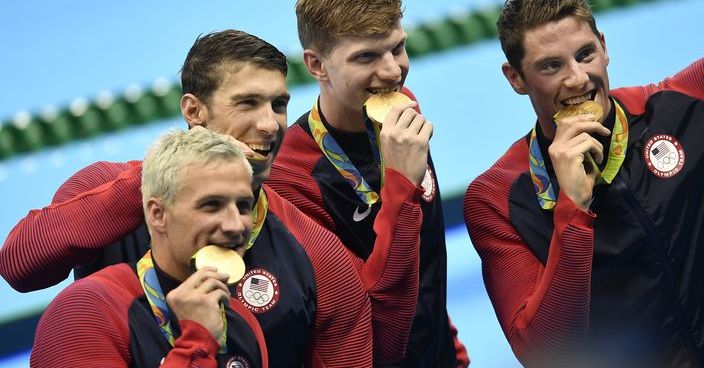 From left, Ryan Lochte, Michael Phelps, Towny Haas and Conor Dwyer from the United States bite their gold medals after the ceremony for the men's 4x200-meter freestyle final during the swimming competitions at the 2016 Summer Olympics, Wednesday, Aug. 10, 2016, in Rio de Janeiro, Brazil. (AP Photo/Martin Meissner)