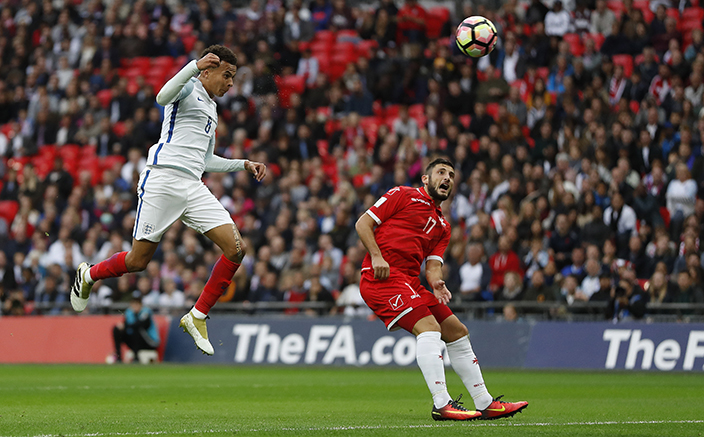 England’s Dele Alli, left, heads a shot towards goal over Malta's Ryan Camilleri during the World Cup Group F qualifying soccer match between England and Malta at Wembley stadium in London, Saturday, Oct. 8, 2016. (AP Photo/Kirsty Wigglesworth)