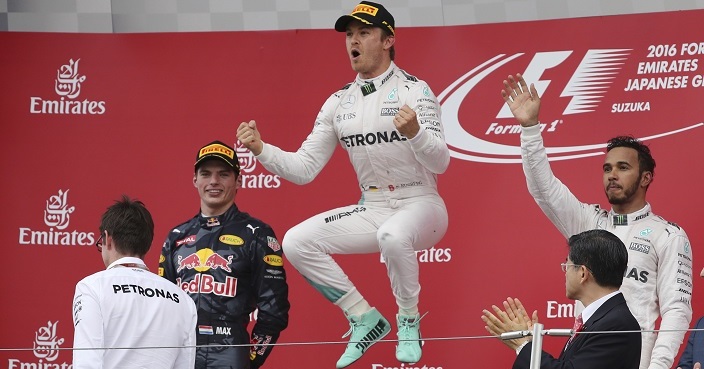 Mercedes driver Nico Rosberg, centre, of Germany celebrates on the podium after winning the Japanese Formula One Grand Prix at the Suzuka International Circuit in Suzuka, Japan, Sunday, Oct. 9, 2016. Red Bull driver Max Verstappen of the Netherlands was second and Mercedes driver Lewis Hamilton, right, of Britain third. (AP Photo/Eugene Hoshiko)