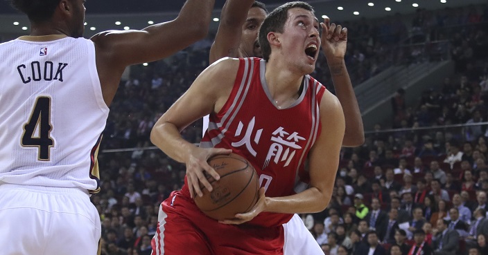 Kyle Wiltjer of the Houston Rockets is tries to score past Quinn Cook of the New Orleans Pelicans in white 4 during a preseasons match in Beijing, China, Wednesday, Oct. 12, 2016. (AP Photo/Ng Han Guan)