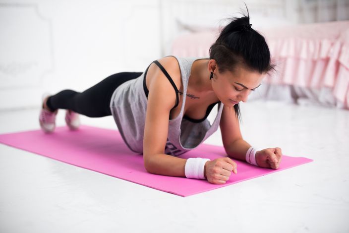 Slim fitness young woman Athlete girl doing plank exercise at