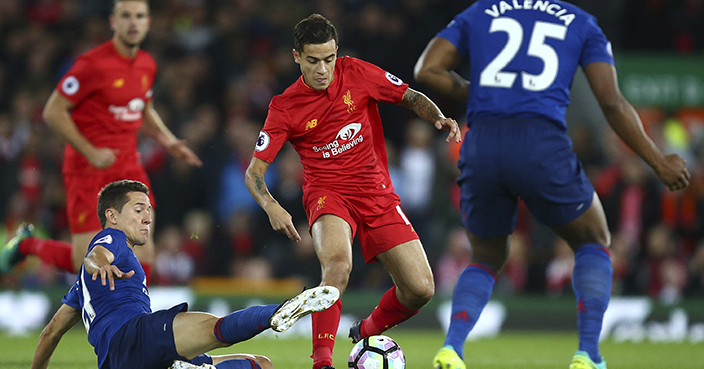 Liverpool's Philippe Coutinho, centre, vies for the ball with Manchester United's Ander Herrera, left, during the English Premier League soccer match between Liverpool and Manchester United at Anfield stadium in Liverpool, England, Monday, Oct. 17, 2016. (AP Photo/Dave Thompson)