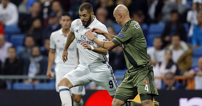 Real Madrid's Karim Benzema, left, is challenged by Legia's Jakub Czerwinski during a Champions League, Group F soccer match between Real Madrid and Legia Warsaw, at the Santiago Bernabeu stadium in Madrid, Tuesday, Oct. 18, 2016. (AP Photo/Francisco Seco)