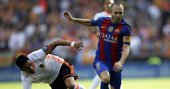 FC Barcelona's Andres Iniesta, right, dribbles past Valencia's Enzo Perez during the Spanish La Liga soccer match between Valencia and FC Barcelona at the Mestalla stadium in Valencia, Spain, Saturday, Oct. 22, 2016. (AP Photo/Manu Fernandez)