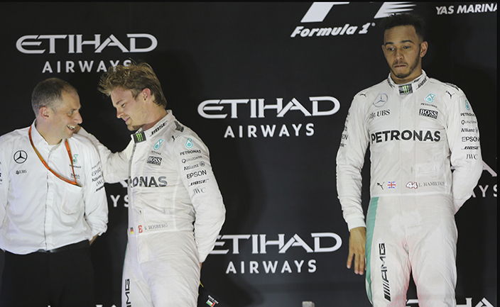 Mercedes driver Nico Rosberg of Germany, left, celebrates as his teammate Mercedes driver Lewis Hamilton of Britain looks on, on the podium after the Emirates Formula One Grand Prix at the Yas Marina racetrack in Abu Dhabi, United Arab Emirates, Sunday, Nov. 27, 2016. (AP Photo/Kamran Jebreili)