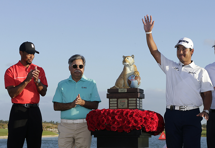 Hideki Matsuyama, right, of Japan, waves as he stands with Tiger Woods, left, and Pawan Munjal,  center, CEO of Hero MotoCorp, near the trophy, after winning the Hero World Challenge golf tournament Sunday, Dec. 4, 2016, in Nassau, Bahamas. (AP Photo/Lynne Sladky)