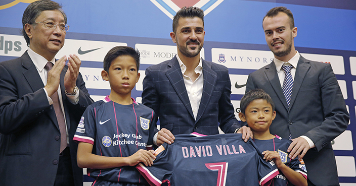New York City FC forward David Villa of Spain, center, poses with Ken Ng, general manager of Kitchee Football Team, left, Pedro Garcia, director of curriculum and coaching education of Kitchee Academy, right, and young players during a press conference in Hong Kong, Friday, Dec. 9, 2016. David Villa's DV7 Soccer Academy will provide the football curriculum for the young players of the Kitchee Academy. (AP Photo/Kin Cheung)