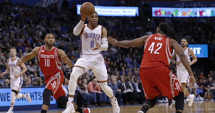Oklahoma City Thunder guard Russell Westbrook (0) passes the ball mid air between Houston Rockets guard Eric Gordon (10) and center Nene Hilario (42) during the second half of an NBA basketball game in Oklahoma City, Friday, Dec. 9, 2016. Houston won 102-99. (AP Photo/Alonzo Adams)