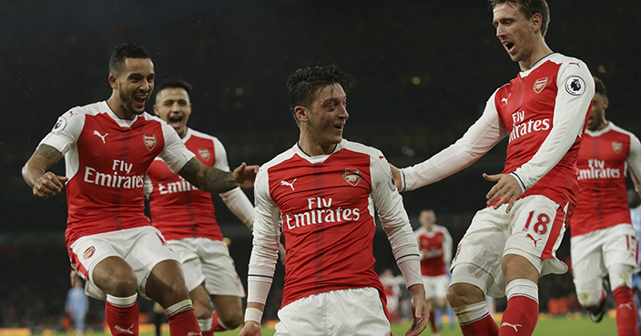 Arsenal's Mesut Ozil, centre, celebrates with his teammates after scoring a goal during the English Premier League soccer match between Arsenal and Stoke City at the Emirates stadium in London, Saturday Dec. 10, 2016. (AP Photo/Tim Ireland)