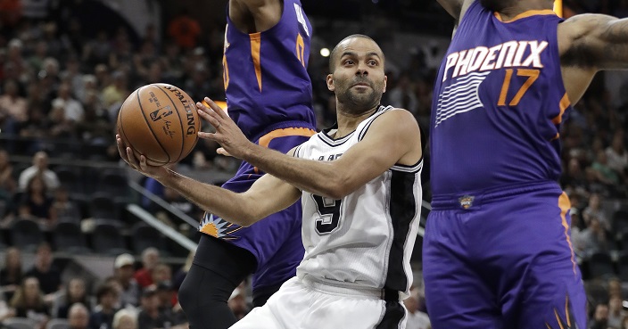 San Antonio Spurs guard Tony Parker (9) drives between Phoenix Suns defenders P.J. Tucker (17) and Phoenix Suns forward Marquese Chriss (0) during the first half of an NBA basketball game, Wednesday, Dec. 28, 2016, in San Antonio. (AP Photo/Eric Gay)