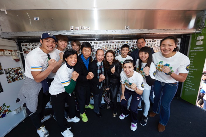 體育專員楊德強（左五）、香港賽馬會慈善信託基金代表陳文端（左七）與一眾精英運動員參觀動感校園校巴。（大會提供圖片）