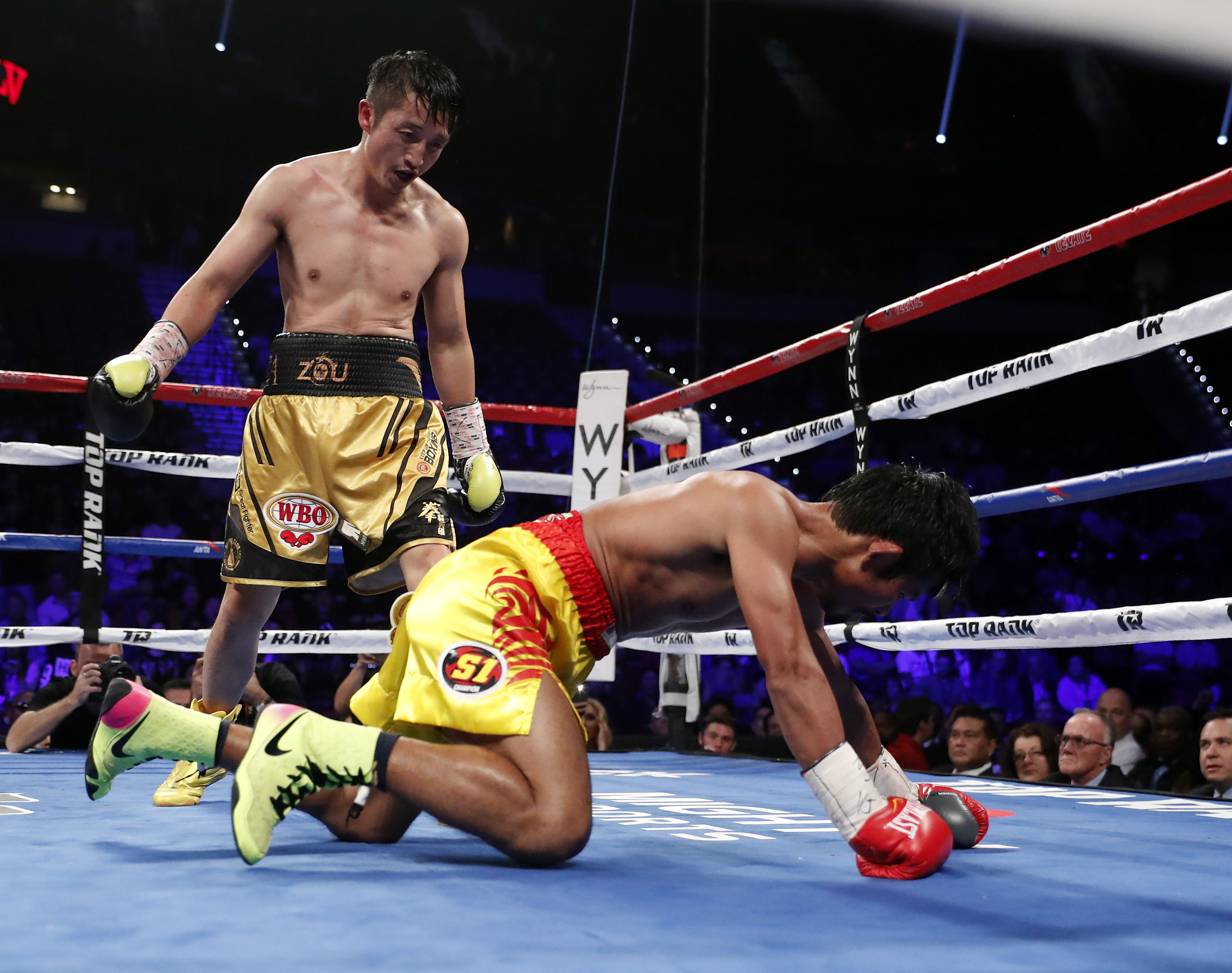 Zou Shiming, of China, stands over Prasitak Phaprom, of Thailand, during their WBO flyweight title boxing match Saturday, Nov. 5, 2016, in Las Vegas. Zou won by unanimous decision. (AP Photo/Isaac Brekken)