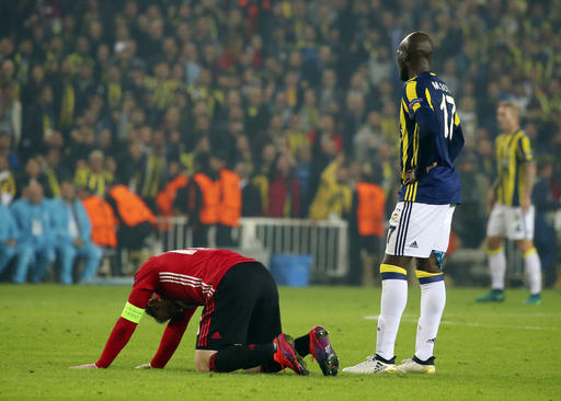 Manchester United's captain Wayne Rooney kneels to the ground after a foul as Fenerbahce's Moussa Sow right, looks on during a Europa League group A soccer match between Fenerbahce and Manchester United, in Istanbul, Thursday, Nov. 3, 2016. Fenerbahce won the match 2-1.(AP Photo)