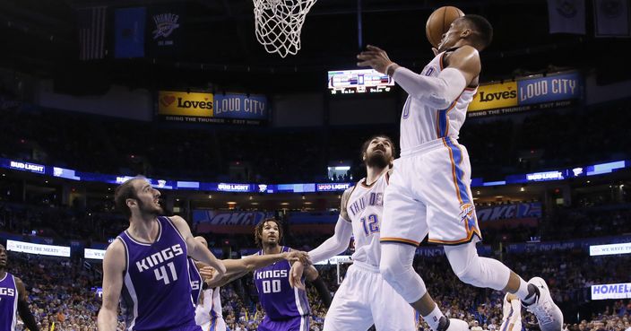 Oklahoma City Thunder guard Russell Westbrook (0) goes up for a dunk in front of Sacramento Kings center Kosta Koufos (41) and teammate Steven Adams (12) in the third quarter of an NBA basketball game in Oklahoma City, Saturday, March 18, 2017. Oklahoma City won 110-94. (AP Photo/Sue Ogrocki)