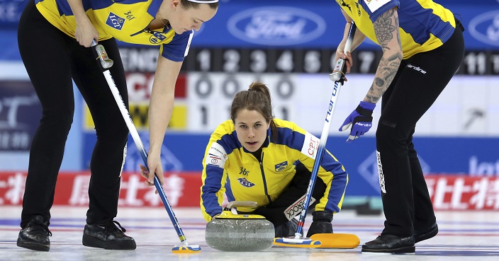 Sweden's Anna Hasselborg, center, releases the stone as Agnes Knochenhauer, left, and Sofia Mabergs, right, prepare to sweep a path during their match against Scotland in the CPT World Women's Curling Championship 2017 in Beijing, China, Saturday, March 25, 2017. (AP Photo/Mark Schiefelbein)