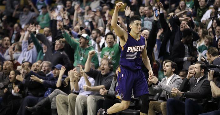 Phoenix Suns guard Devin Booker (1) gestures after he scored a basket, while fans cheer him at TD Garden in the fourth quarter of the team's NBA basketball game against the Boston Celtics, Friday, March 24, 2017, in Boston. Booker scored 70 points in the game. The Celtics won 130-120. (AP Photo/Elise Amendola)