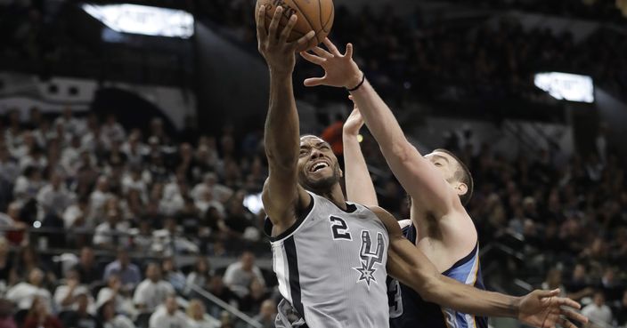 San Antonio Spurs forward Kawhi Leonard (2) drives to the basket past Memphis Grizzlies center Marc Gasol (33) during the second half in Game 1 of a first-round NBA basketball playoff series, Saturday, April 15, 2017, in San Antonio. (AP Photo/Eric Gay)