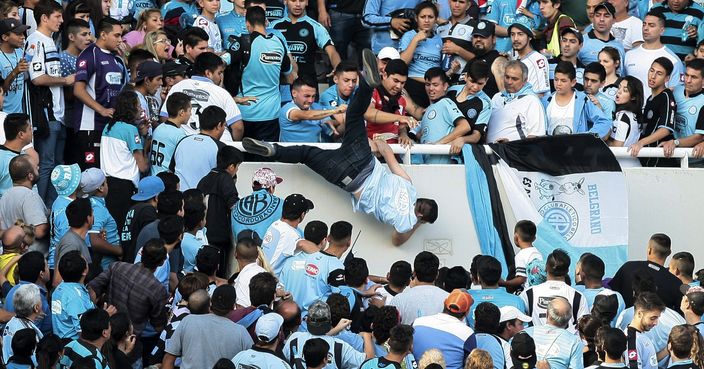 In this Saturday, April 15, 2017 photo, Emanuel Balbo is thrown from the stands by other fans during a match between Belgrano and Talleres, in Cordoba, Argentina. Balbo has been declared brain dead after he was chased down the terraces of a stadium and thrown from the bleachers. Balbo's father says his son was attacked by a mob after he faced off with a man that Balbo blamed for killing his brother. (AP Photo/Alvaro Martin Corral)