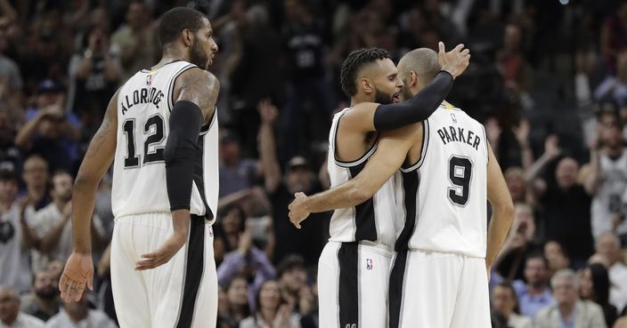 San Antonio Spurs forward LaMarcus Aldridge (12), guard Patty Mills (8) and guard Tony Parker (9) celebrate after a score during the second half of Game 5 in a first-round NBA basketball playoff series against the Memphis Grizzlies, Tuesday, April 25, 2017, in San Antonio. San Antonio won 116-103. (AP Photo/Eric Gay)