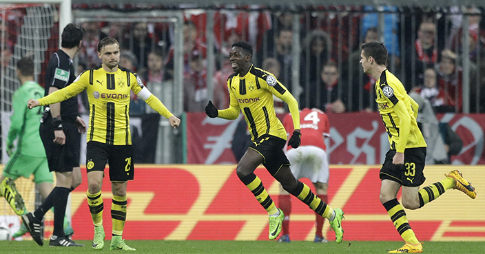 Dortmund's Ousmane Dembele, center, celebrates after scoring his side's third goal during the German Soccer Cup semifinal match between FC Bayern Munich and Borussia Dortmund at the Allianz Arena stadium in Munich, Germany, Wednesday, April 26, 2017. (AP Photo/Matthias Schrader)