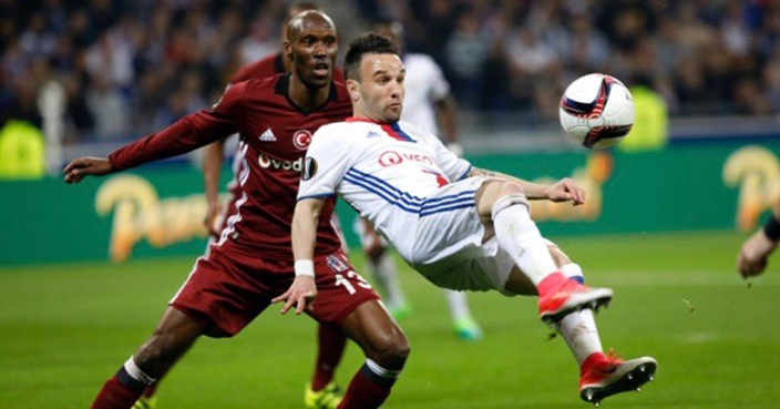 Lyon's Mathieu Valbuena, right, kicks the ball as he challenges with Besiktas' Atiba Hutchinson, left, during their Europa League quarterfinal soccer match in Decines, near Lyon, central France, Thursday, April 13, 2017. (AP Photo/Laurent Cipriani)
