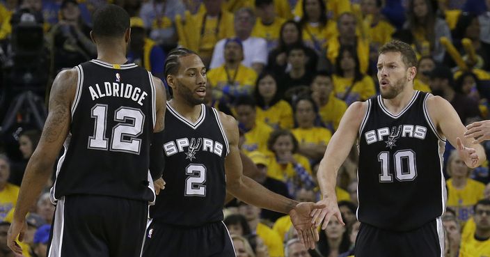 San Antonio Spurs forward Kawhi Leonard (2) is congratulated by forward LaMarcus Aldridge (12) and forward David Lee (10) after scoring against the Golden State Warriors during the first half of Game 1 of the NBA basketball Western Conference finals in Oakland, Calif., Sunday, May 14, 2017. (AP Photo/Jeff Chiu)