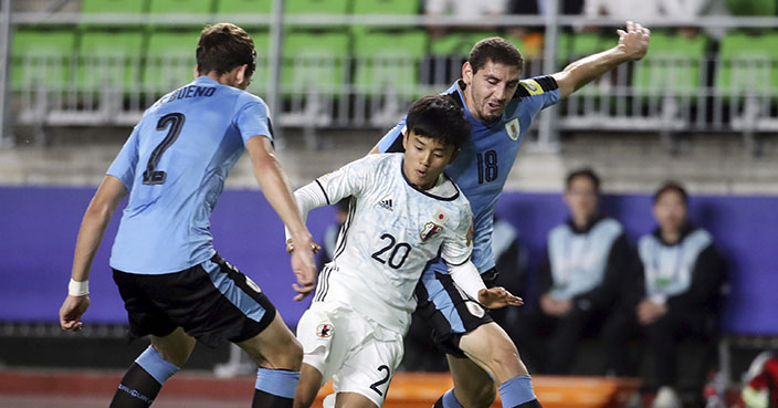 Japan's Takefusa Kubo, center, fights for the ball with Uruguay's Agustin Rogel, right, and Santiago Bueno during their Group D soccer match in the FIFA U-20 World Cup Korea 2017 at Suwon World Cup Stadium in Suwon, South Korea, Wednesday, May 24, 2017. (Im Hun-jung/Yonhap via AP)