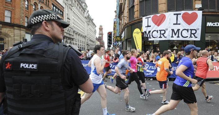 An armed police officer stands at the start of the Great Manchester Run in central Manchester, England, Sunday May 28, 2017. The hunt is still on for suspects in the Manchester bombing, and members of attacker Salman Abedi's network may still be at large, Britain's interior minister said Sunday. (AP Photo/Rui Vieira)