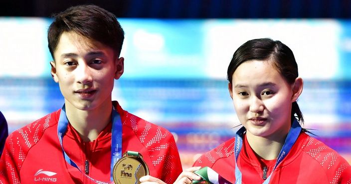 Gold medal winning Ren Qian and Lian Junjie of China pose on the podium during the medal ceremony of the mixed diving 10m synchronized platform final at the Swimming World Championships 2017 in Duna Arena in Budapest, Hungary, Saturday, July 15, 2017. (Tibor Illyes/MTI via AP)
