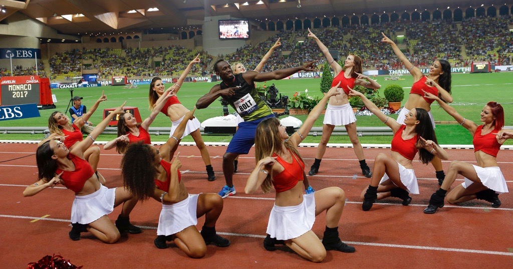 Jamaica's Usain Bolt, surrounded by cheerleaders, gestures after the podium ceremony at the IAAF Diamond League Athletics meeting at the Louis II Stadium in Monaco, Friday, July 21, 2017. In the last Diamond League race of his glittering career, Usain Bolt has held on to win the 100 meters at the Herculis track meet in Monaco. (AP Photo/Claude Paris)