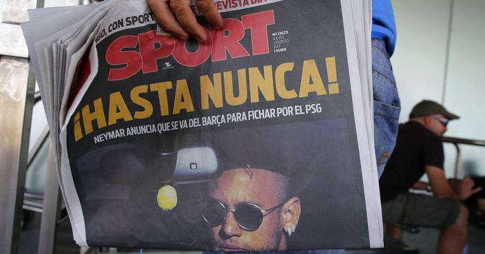 A journalist holds a Sport newspaper with a picture of FC Barcelona's Neymar reading in Spanish 