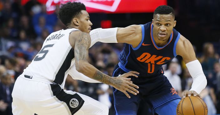 Oklahoma City Thunder guard Russell Westbrook (0) drives around San Antonio Spurs guard Dejounte Murray (5) during the first quarter of an NBA basketball game in Oklahoma City, Sunday, Dec. 3, 2017. (AP Photo/Sue Ogrocki)