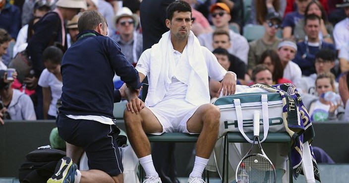 Novak Djokovic receives medical treatment during his Men's Singles Match against Tomas Berdych on day nine of the Wimbledon Tennis Championships at The All England Lawn Tennis and Croquet Club, London, Wednesday, July 12, 2017. (Gareth Fuller/PA via AP)