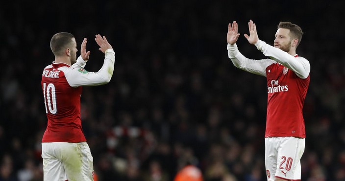 Arsenal's Jack Wilshere, left, celebrates with his teammate Shkodran Mustafi at the end of the English League Cup semifinal second leg soccer match between Chelsea and Arsenal at the Emirates stadium in London, Wednesday, Jan.24, 2018. Arsenal won 2-1 and will play the final of the tournament. (AP Photo/Matt Dunham)