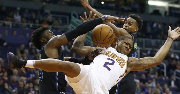 Phoenix Suns guard Isaiah Canaan (2) is fouled by Dallas Mavericks guards Wesley Matthews, left, and Yogi Ferrell, right, during the first half of an NBA basketball game Wednesday, Jan. 31, 2018, in Phoenix. (AP Photo/Ross D. Franklin)