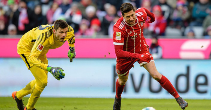 Bayern's Robert Lewandowski, right, runs past Hertha goalkeeper Rune Jarstein during the German Bundesliga soccer match between FC Bayern Munich and Hertha BSC Berlin in Munich, southern Germany, Saturday, Feb. 24, 2018. (Matthias Balk/dpa via AP)