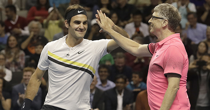 Roger Federer, of Switzerland, left, celebrates with partner Bill Gates as they play an exhibition tennis match against Jack Sock and Savannah Guthrie in San Jose, Calif., Monday, March 5, 2018. (AP Photo/Jeff Chiu)