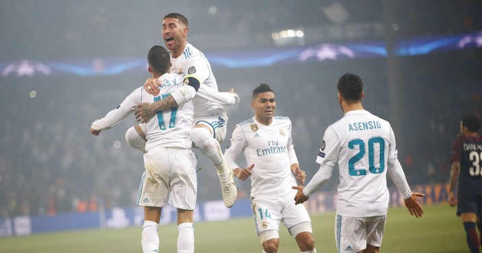 Real Madrid's Sergio Ramos jumps in the arms of Real Madrid's Lucas Vazquez, left, as Real Madrid's Casemiro, third left, and Real Madrid's Marco Asensio join in celebrating scoring their side's first goal during the Champions League round of sixteen second leg soccer match between Paris St. Germain and Real Madrid at the Parc des Princes stadium in Paris, France, Tuesday, March 6, 2018. (AP Photo/Christophe Ena)