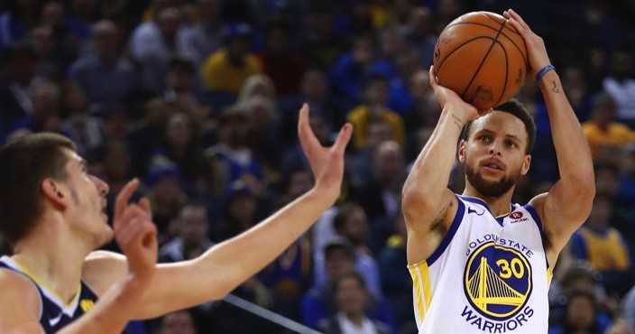 Golden State Warriors' Stephen Curry, right, shoots against Denver Nuggets' Nikola Jokic (15) during the second half of an NBA basketball game Monday, Jan. 8, 2018, in Oakland, Calif. Golden State won, 124-114. (AP Photo/Ben Margot)