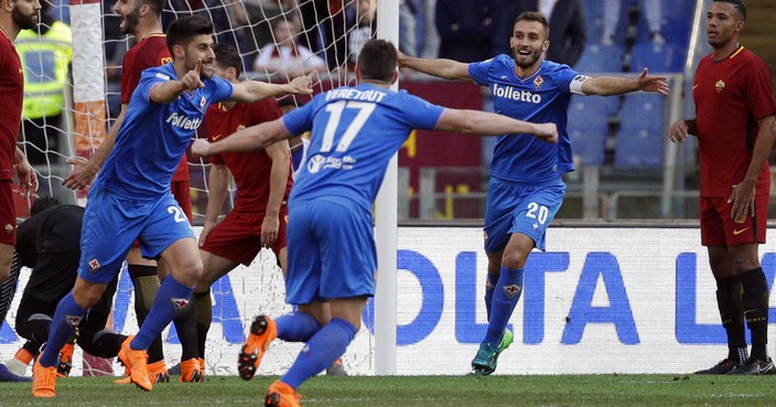 Fiorentina's Marco Benassi, left, celebrates with his teammates Jordan Veretout, center, and German Pezzella after he scored during a Serie A soccer match between Roma and Fiorentina, at Rome's Olympic Stadium, Saturday, April 7, 2018. (AP Photo/Gregorio Borgia)