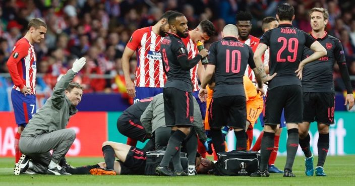 Arsenal's Laurent Koscielny receives a medical help during the Europa League semifinal, second leg soccer match between Atletico Madrid and Arsenal at the Metropolitano stadium in Madrid, Spain, Thursday, May 3, 2018. (AP Photo/Francisco Seco)