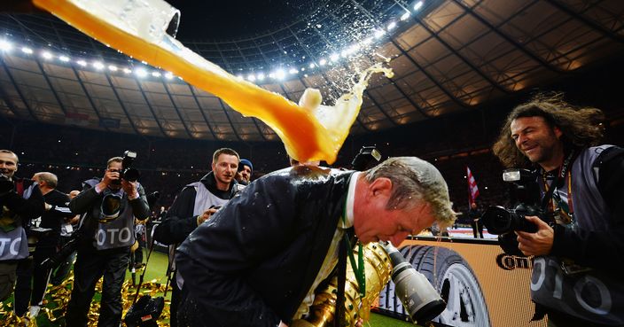 BERLIN, GERMANY - JUNE 01:  Jupp Heynckes head coach of Bayern Muenchen is showered with beer as he celebrates victory in his last match after the DFB Cup Final match between FC Bayern Muenchen and VfB Stuttgart at Olympiastadion on June 1, 2013 in Berlin, Germany. Bayern become the first German team to win the treble of league, cup and European Cup/Champions League.  (Photo by Stuart Franklin/Bongarts/Getty Images)