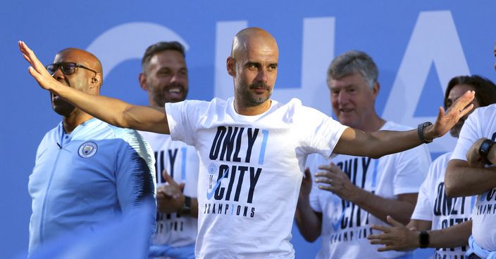 Manchester City soccer team manager Pep Guardiola acknowledges supporters during the British Premier League champions trophy parade in Manchester, England, Monday May 14, 2018.  Manchester City soccer team paraded through the streets of Manchester aboard open top buses, celebrating winning the Premier League title by a record 19 points. (Richard Sellers/PA via AP)
