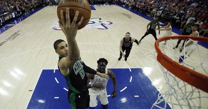 Boston Celtics' Jayson Tatum, left, goes up for a dunk past Philadelphia 76ers' Joel Embiid during the first half of Game 4 of an NBA basketball second-round playoff series, Monday, May 7, 2018, in Philadelphia. (AP Photo/Matt Slocum)