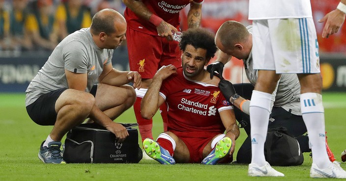Liverpool's Mohamed Salah gets medical treatment during the Champions League Final soccer match between Real Madrid and Liverpool at the Olimpiyskiy Stadium in Kiev, Ukraine, Saturday, May 26, 2018. (AP Photo/Sergei Grits)