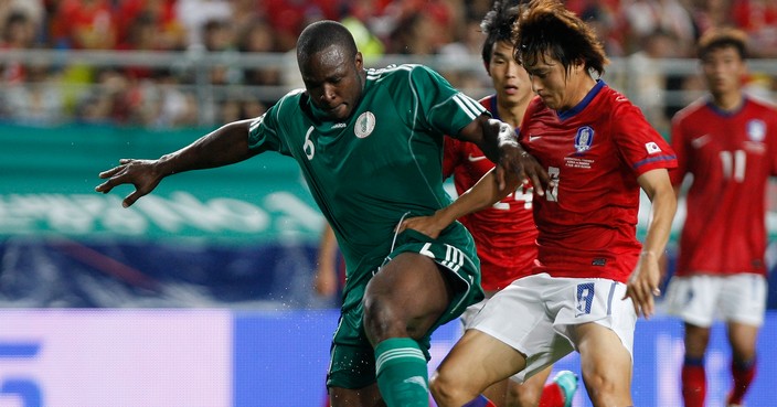 SUWON, SOUTH KOREA - AUGUST 11:  Baek Ji-Hoon of South Korea and Shittu Daniel Olusola of Nigeria compete for the ball during the international friendly match between South Korea and Nigeria at Suwon World Cup Stadium on August 11, 2010 in Suwon, South Korea.  (Photo by Chung Sung-Jun/Getty Images)