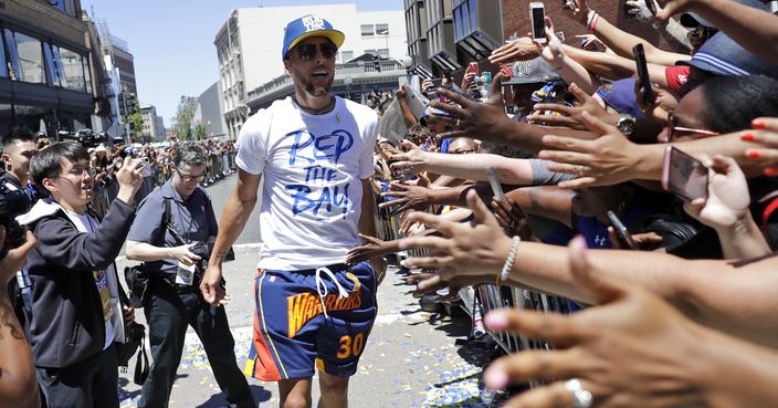 Golden State Warriors' Stephen Curry celebrates with fans during the team's NBA basketball championship parade, Tuesday, June 12, 2018, in Oakland, Calif. (AP Photo/Marcio Jose Sanchez)